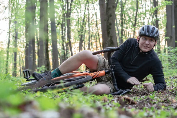 a young guy fell on a bicycle in the forest, was injured