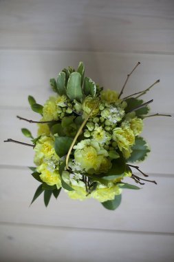 Tahta arka planda sarı çiçek demeti