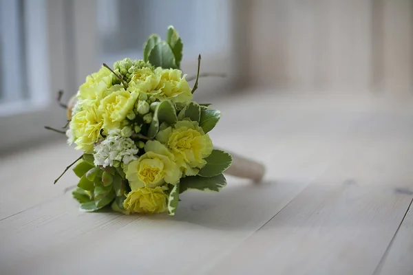 Bouquet of yellow flowers on wooden background