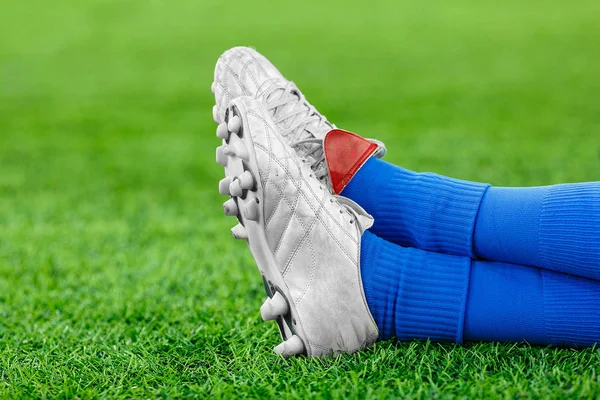 Benen av en spelare i fotboll på en grön gräsmatta — Stockfoto