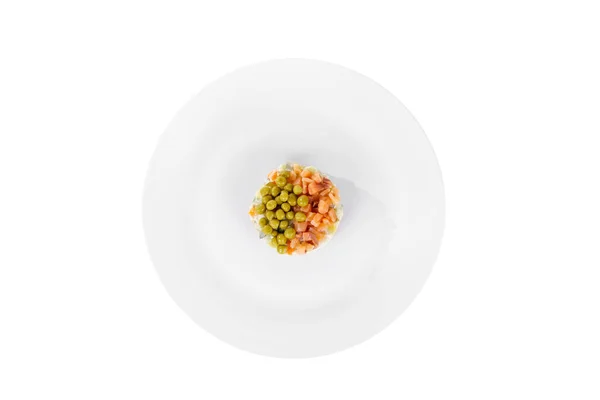 Salade russe aux petits pois sur assiette blanche isolée — Photo