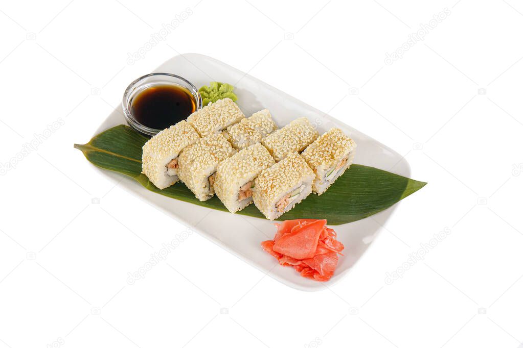 Sushi, rolls, uramaki Alaska, with avocado, cucumber, crab meat, raw seafood, soy sauce, marinated ginger and wasabi. Food on a banana leaf, on plate, white isolated background side view