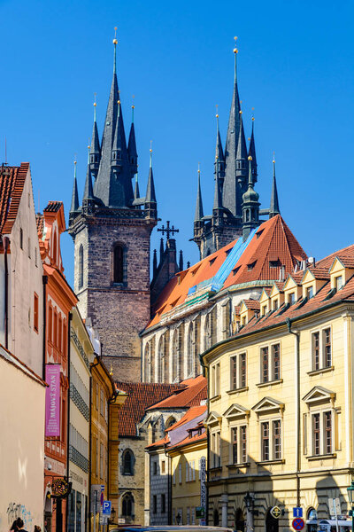 The Church of our Lady before Tyn from an intersting perspective as seen from a sidewalk with colorful buildings on both sides. Prague, Czech Republic