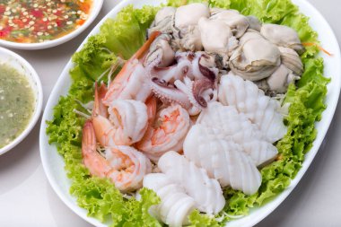 Buğulanmış karides ve kalamar ve çiğ istiridye