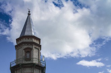 Sünni Müslümanların Camii. Minare beyaz bulutlar ile mavi gökyüzüne karşı.