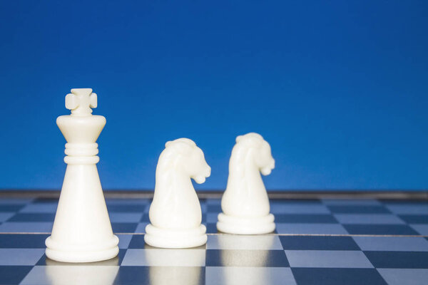 Chess as a business. A white figure controls two white horses.