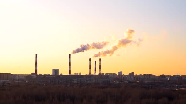 工业景观，火力发电厂的管道在日落时。 植物背景在夕阳西下的天空，污染环境 — 图库视频影像