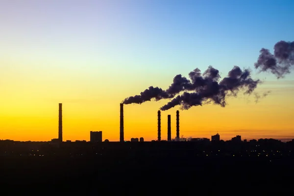 factories smoke from pipes at sunset