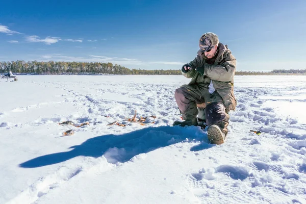 Pesca de invierno Pescador disfrutando de un día en el hielo —  Fotos de Stock