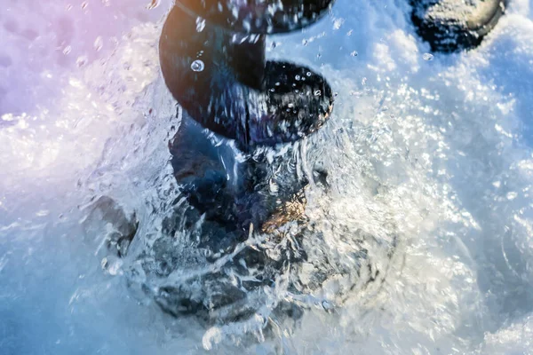 Pêche d'hiver. Vis à glace près du trou dans le mouvement de mise au point sélective de la glace — Photo