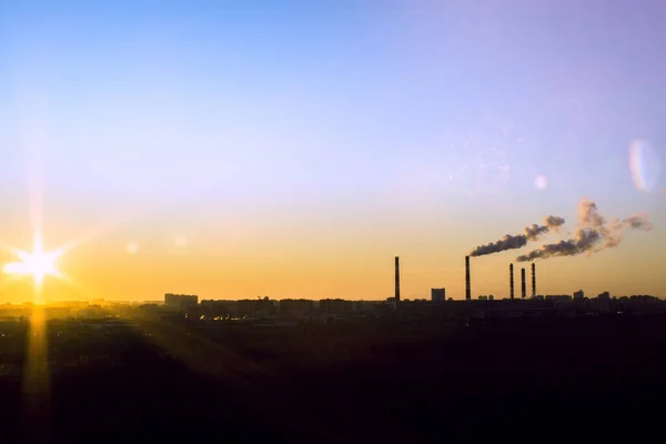 Silhuett av rökning fabriksledningar mot solnedgången landskapet. Rör avger tjock rök. Begreppet miljöförorening genom ekologi — Stockfoto