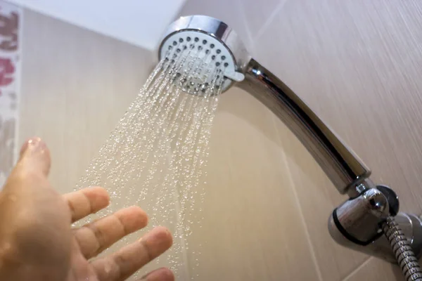 Närbild öppnas och stängt vatten flyter från duschhuvud i badrummet för att ta ett duschkoncept. — Stockfoto