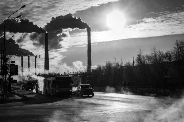 都市の街中で煙を出す発電所の煙台。道路レトロなスタイルの都市。生態学 — ストック写真