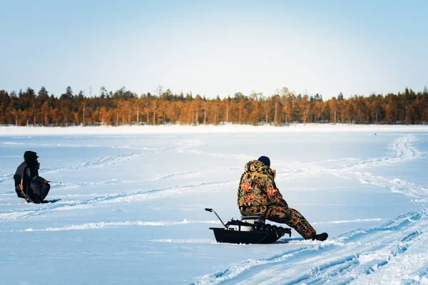 Fishermen on the winter lake fishing on the background of the winter forest. Winter sport winter fishing fishing in the winter — Stock Photo, Image