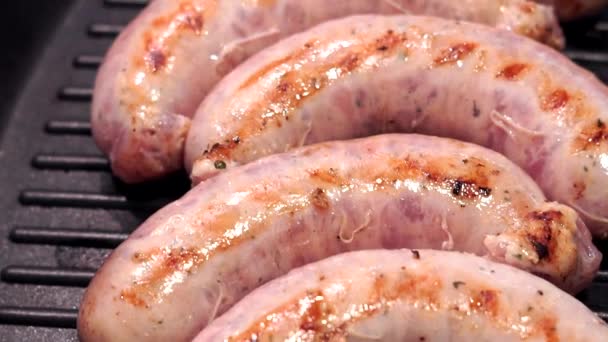 Saucisses grillées sur une poêle à griller close-up. La préparation de saucisses, kupaty de porc — Video