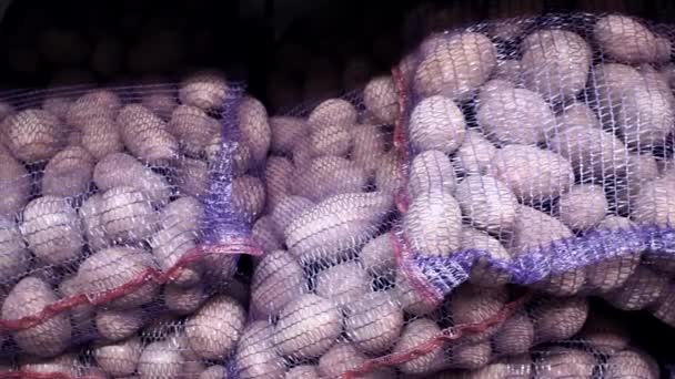 Patatas en una bolsa en los estantes del mercado. Venta, compra de verduras — Vídeo de stock