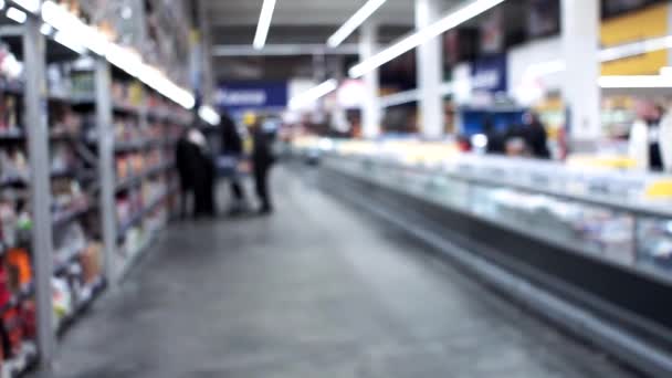 超级市场，销售和购买商品的背景，伪造。 开购物车的人 人们在超市购物，背景模糊不清. — 图库视频影像