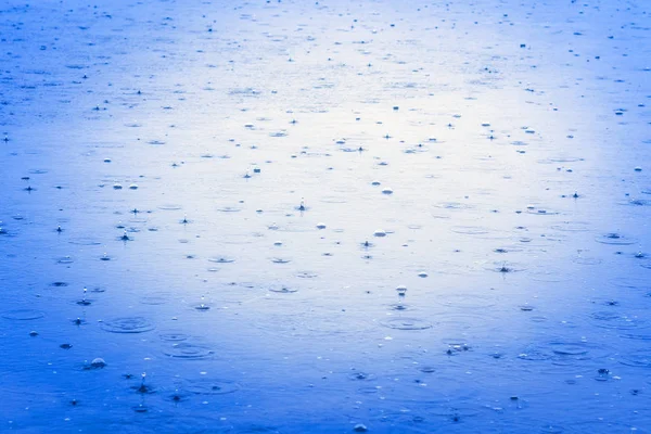 Gotas de lluvia en la superficie del lago. El agua turquesa del río. Clima lluvioso — Foto de Stock