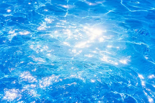 Niebieska woda w basenie. tło powierzchni wody. faktura, niebieska woda, jasne promienie słońca — Zdjęcie stockowe