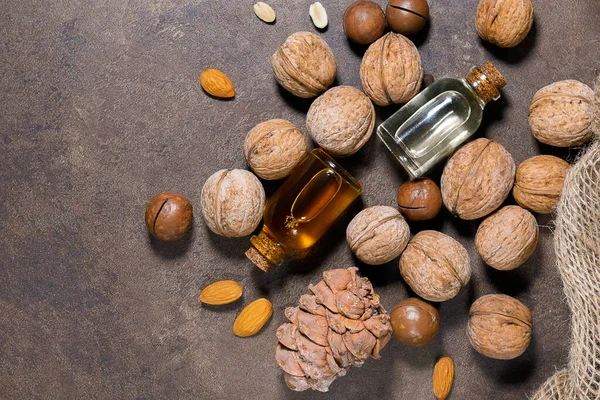 cosmetic oil from nuts top view, walnuts, almonds, macadamia, pine nuts.