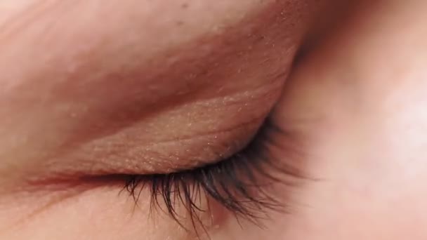 Macro close-up oog knippert. Jonge vrouw opent en sluit haar mooie oog. — Stockvideo