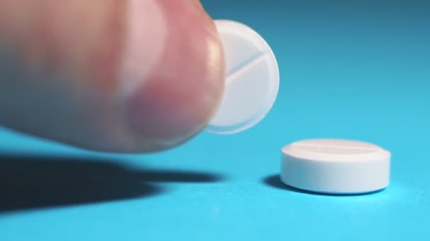 Держать белые круглые таблетки экстремально близко. медицинская концепция, принимать таблетки — стоковое видео