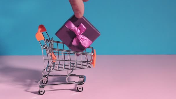 Καλάθι αγορών. Καλάθι αγορών με πολύχρωμα κουτιά δώρων, παρουσιάζει την έννοια των αγορών, θέση για το χώρο αντιγραφής κειμένου. e-Commerce, ένα χέρι παίρνει ένα δώρο, online ψώνια — Αρχείο Βίντεο