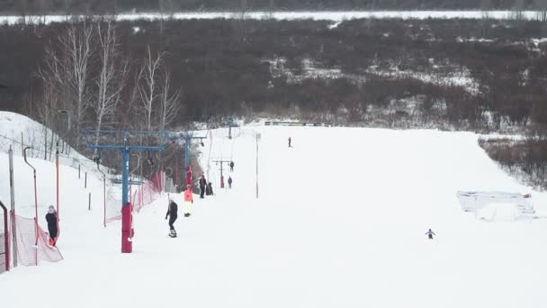 Tyumen, Rússia-12.20.2019: Estância de esqui em Tyumen. pessoas usando ski T-bar elevador na encosta de neve no inverno. Esportes de inverno, dezembro na Sibéria, entretenimento de lazer — Vídeo de Stock