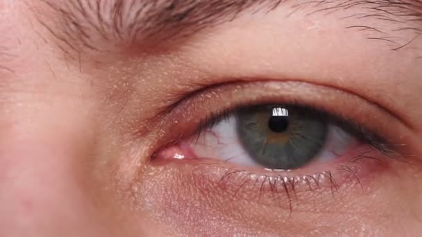 Zielone oko młodego faceta zbliżenie makro szczegół. zmęczenie, bezsenność, oczy tysiąclecia, wybiórcze skupienie — Wideo stockowe
