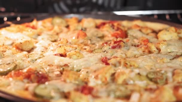 Pizzan bakas i ugnen, matlagning pizza i köket. Ost på pizza smälter från ugnen värme, närbild, makro — Stockvideo