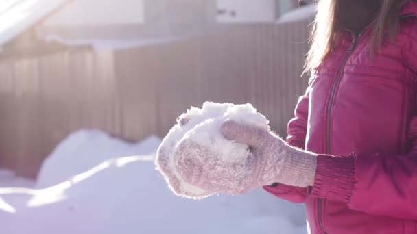 Kvinna spyr upp mjuk nysnö, tidig vintertid. vintersemester, vinter, solig dag. selektivt fokus — Stockvideo