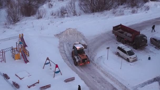 トラクターの雪のブロワーの道をクリアします。雪の除去機氷の山を登る。トップ表示. — ストック動画