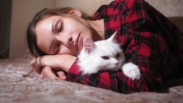 Jong meisje slapen met een kat op het bed — Stockvideo