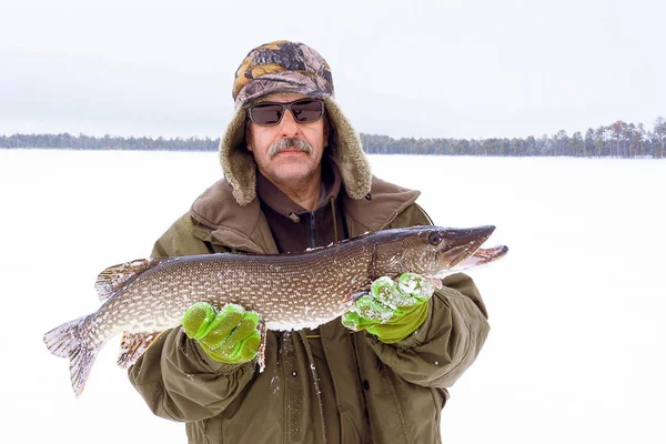 Winter fishing. a man holds a trophy catch, a large fish pike — Stock Photo, Image