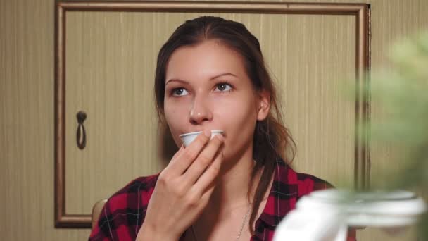 Молодая девушка в рубашке, пьет китайский чай из миски — стоковое видео