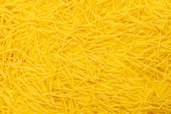 Kleine rauwe pasta achtergrond. Bovenaanzicht. Filini vermicellen close-up plat leggen. — Stockfoto