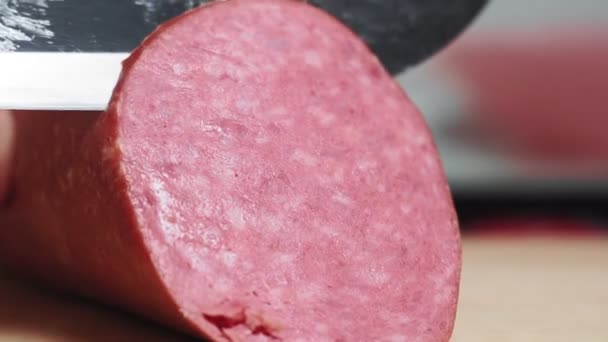 Cut smoked sausage with knife. Sausage slices lie on a cutting board close-up. Cook the meat slices — Stok video
