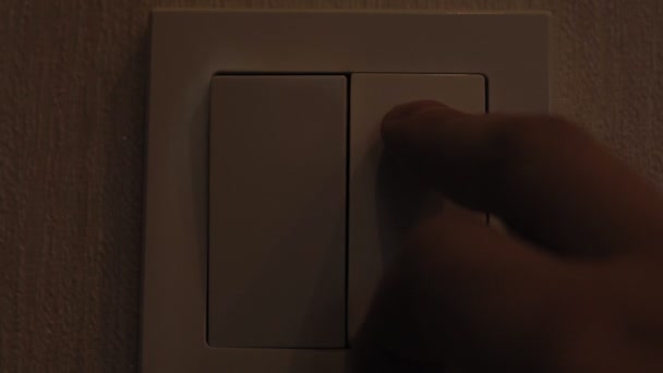 Mans Hand Turning Light Switch In Double Switch. turning on the light — Stockvideo
