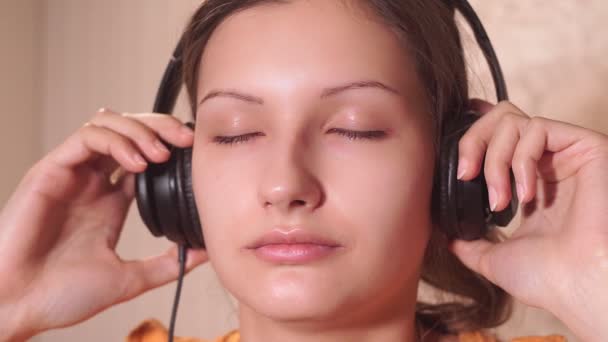 Retrato de una joven escuchando música relajante con los ojos cerrados . — Vídeo de stock