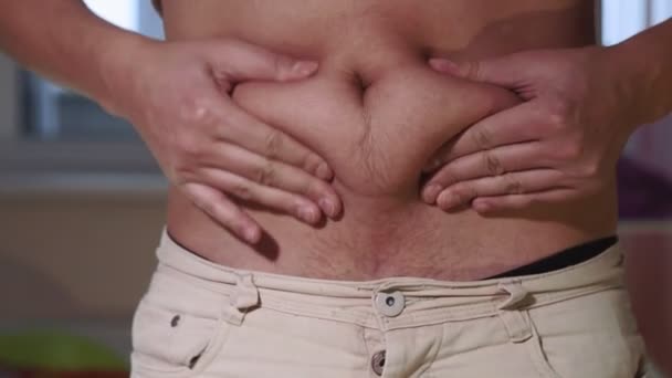 Man is posing showing a fat stomach. overweight, young man — Stockvideo