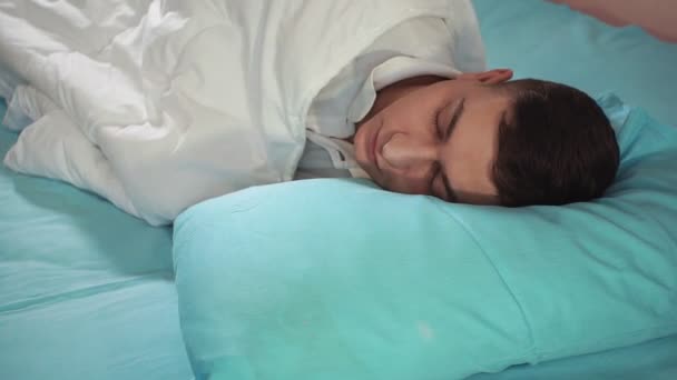 Geht zu Bett, bedeckt mit einer Decke, ein junger Mann, in Großaufnahme. Gute Nacht, guter Schlaf — Stockvideo