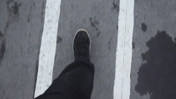 Walking on wet asphalt footpath concept of freedom. goes look down in sneakers — Stock Video