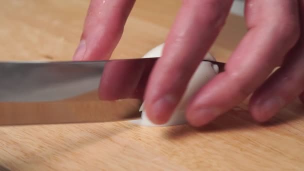 Cuts boiled eggs close - up with a knife. ingredient for salads and other dishes — Stock Video