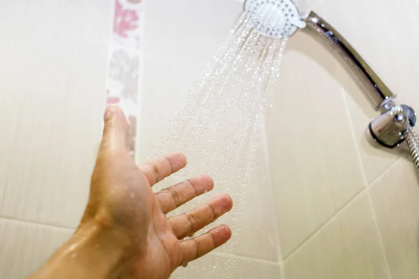 一名男子用手部淋浴墙对淋浴间的水温进行了近距离检查 选择性重点 — 图库照片
