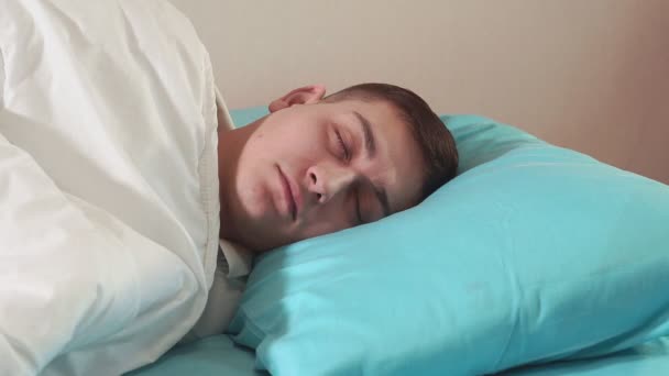 Joven millennial chico de cerca durmiendo. enfoque suave. se despierta por la mañana, alegre — Vídeos de Stock