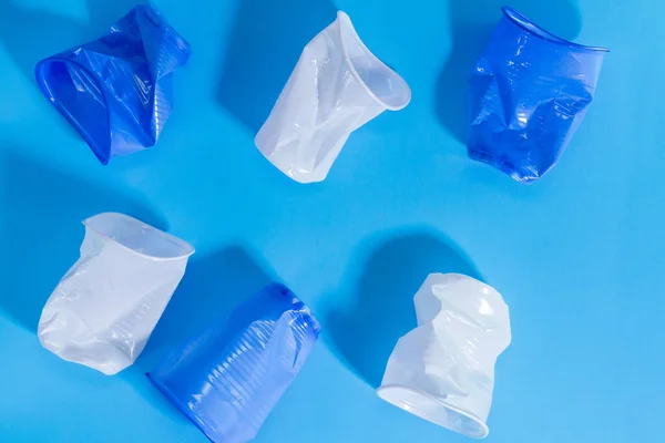 plastic tableware on a blue background. the concept of recycling and abandoning plastic dishes. top view Flat lay