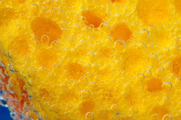 yellow dish washing sponge macro. bubbles, under water. porous macro sponge.