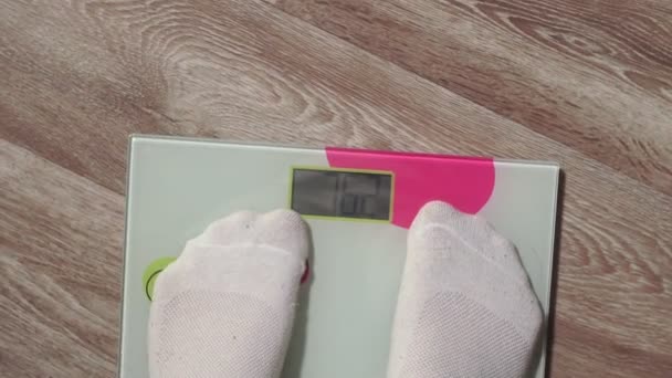 L'uomo che calpesta le scale da vicino. controlla il tuo peso. gambe uomo in avvicinamento allo strumento digitale di pesatura — Video Stock