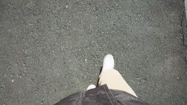 Ein Mann in weißen Turnschuhen läuft an einem strahlend sonnigen Tag in Jeans über den Bürgersteig. pov video, erste person — Stockvideo