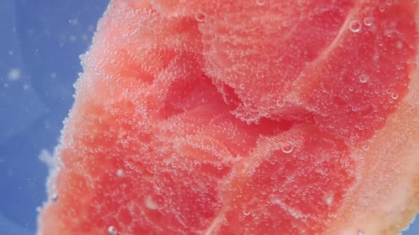 Čerstvý grapefruit kapal do vody s bublinkami. selektivní zaměření šťavnaté zralé ovoce ve vodě close-up, makro — Stock video